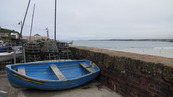 SX08684 Blue rowboat on resting near harbour wall.jpg